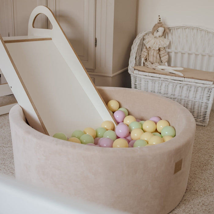 Beige ball pit with slide attachment and multicolored balls for toddler play