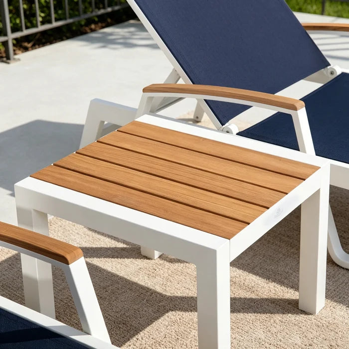 Peak Home Furnishings teak outdoor end table paired with a navy blue mesh lounge chair on a sunny backyard patio deck.