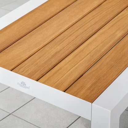 Close-up of Peak Home Furnishings logo on the white powder-coated aluminum frame with natural Grade-A teak slatted tabletop.
